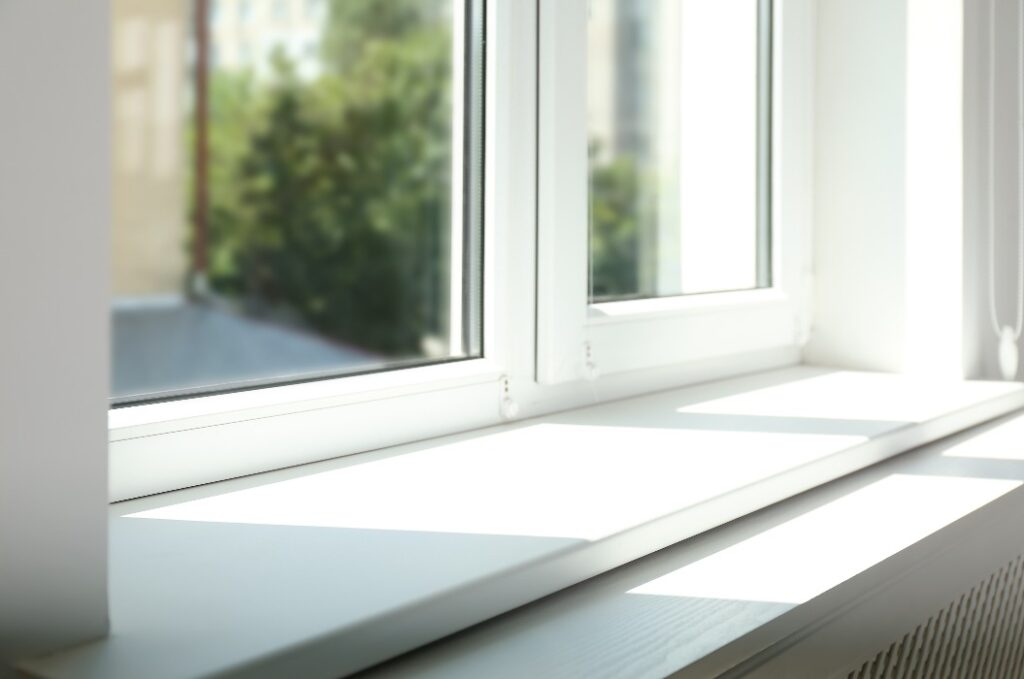 Nahaufnahme eines Fensters mit leerer, weißer Fensterbank